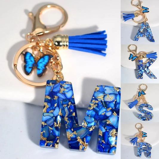 Buchstaben-Schlüsselanhänger in Blau mit Schmetterling und Quaste